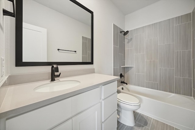 full bathroom with tiled shower / bath, vanity, and toilet