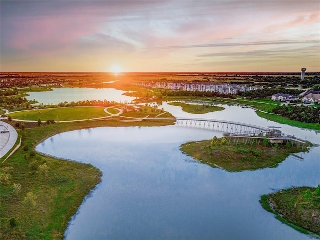 aerial view at dusk featuring a water view