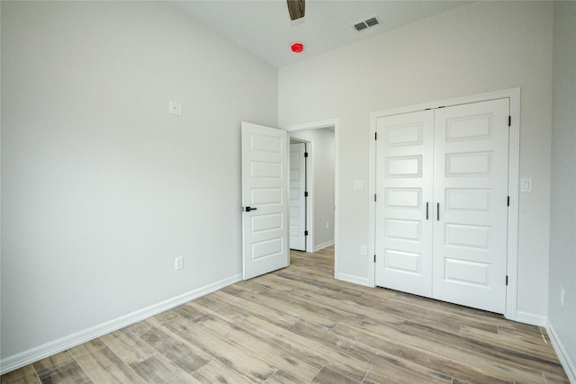 unfurnished bedroom with a closet and light wood-type flooring