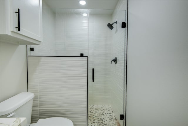 bathroom with toilet and a shower with door