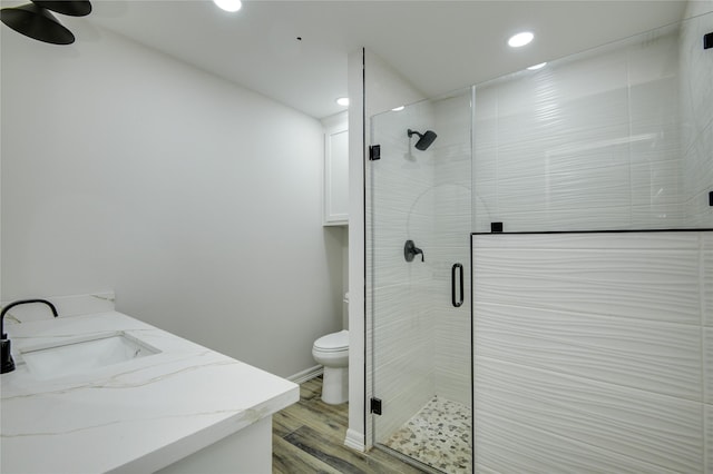 bathroom with walk in shower, vanity, toilet, and hardwood / wood-style flooring