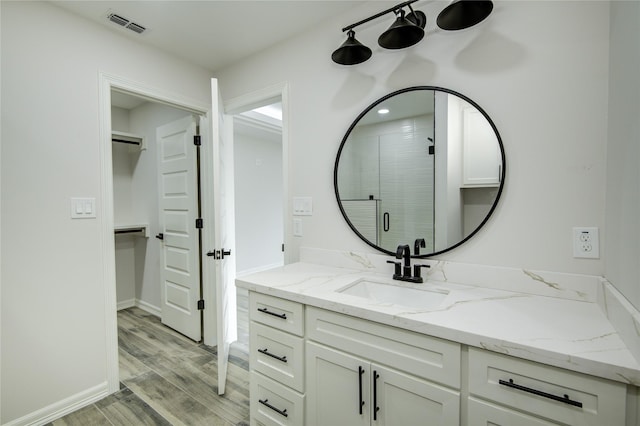 bathroom featuring a shower with door, vanity, and hardwood / wood-style floors