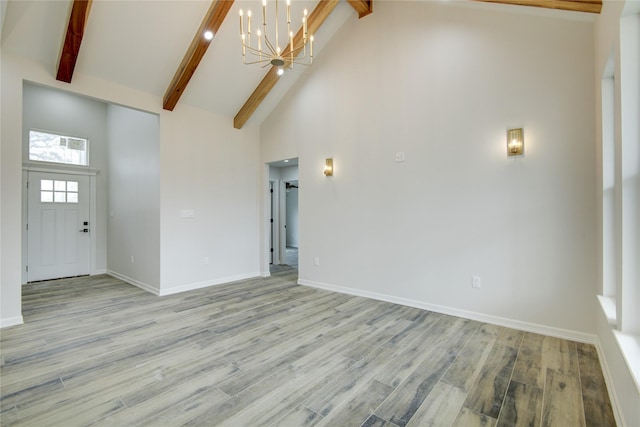 unfurnished living room featuring beam ceiling, high vaulted ceiling, and light hardwood / wood-style flooring