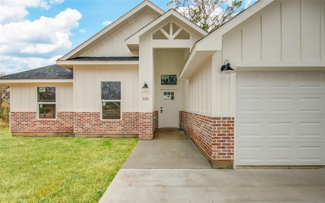 view of exterior entry featuring a garage and a lawn