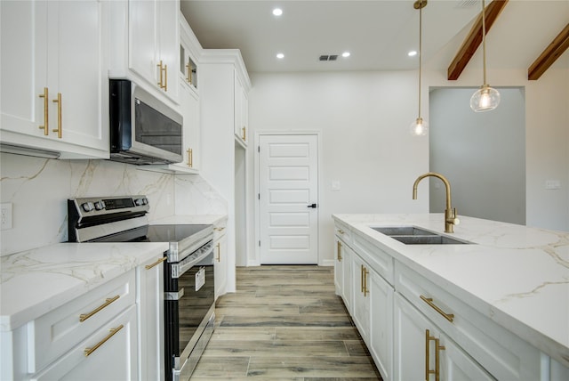 kitchen with stainless steel appliances, sink, hanging light fixtures, and white cabinets