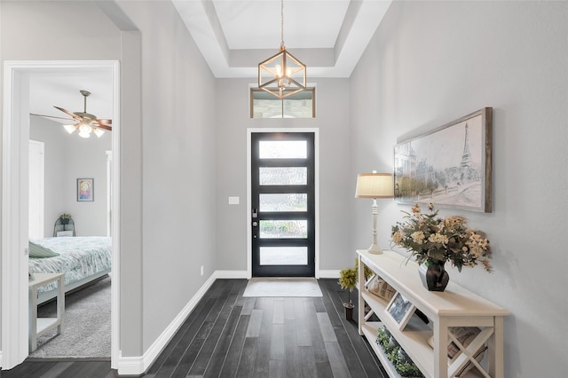 entryway featuring a notable chandelier, dark hardwood / wood-style floors, and a raised ceiling