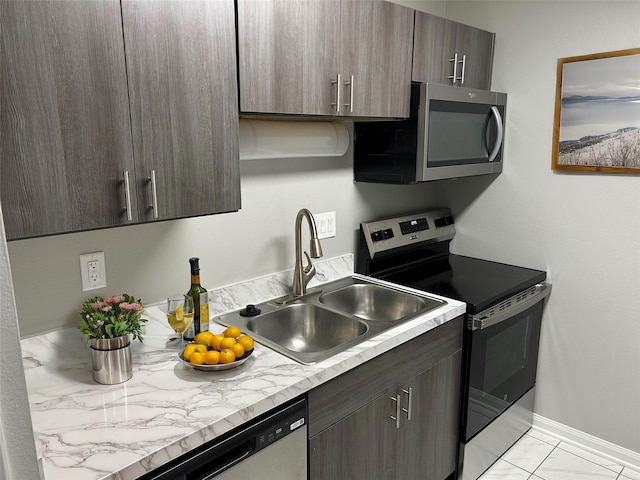 kitchen featuring stainless steel appliances, sink, and dark brown cabinetry