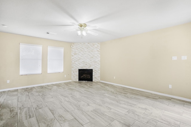 unfurnished living room with ceiling fan and a fireplace