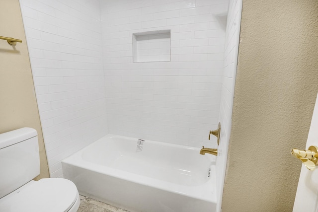 bathroom featuring tiled shower / bath and toilet