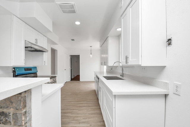 kitchen featuring white cabinetry, appliances with stainless steel finishes, sink, and light hardwood / wood-style flooring