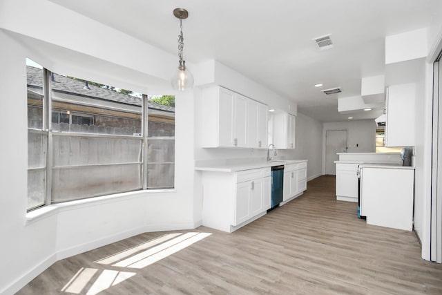 kitchen with dishwashing machine, sink, light hardwood / wood-style flooring, and white cabinets