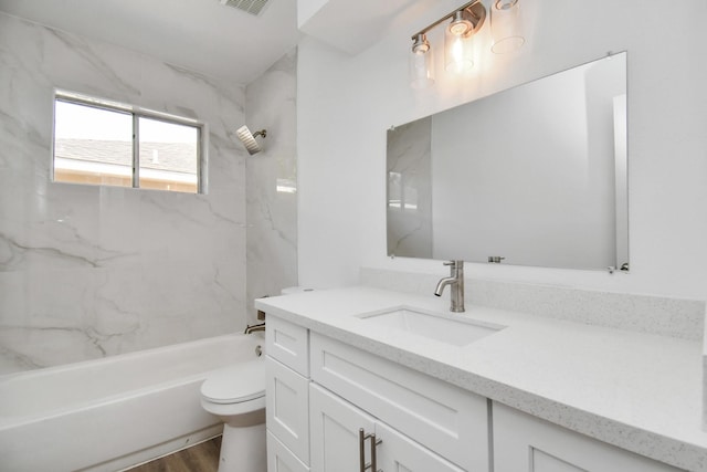 full bathroom featuring vanity, tiled shower / bath, hardwood / wood-style flooring, and toilet