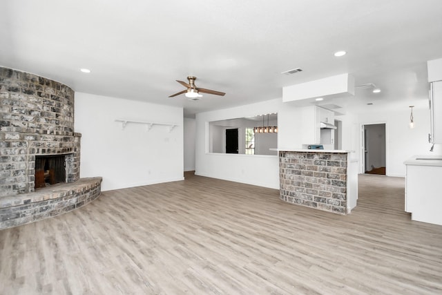 unfurnished living room featuring hardwood / wood-style flooring, a fireplace, and ceiling fan