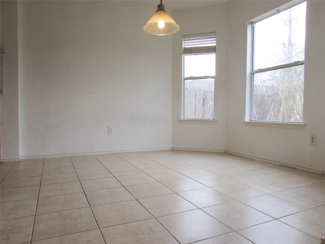 unfurnished room with a healthy amount of sunlight and light tile patterned floors