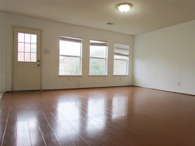 empty room with hardwood / wood-style flooring and a wealth of natural light