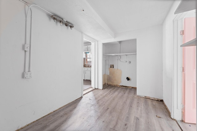 clothes washing area with light hardwood / wood-style flooring