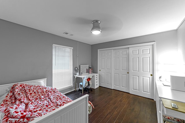 bedroom featuring dark hardwood / wood-style flooring, a closet, and ceiling fan