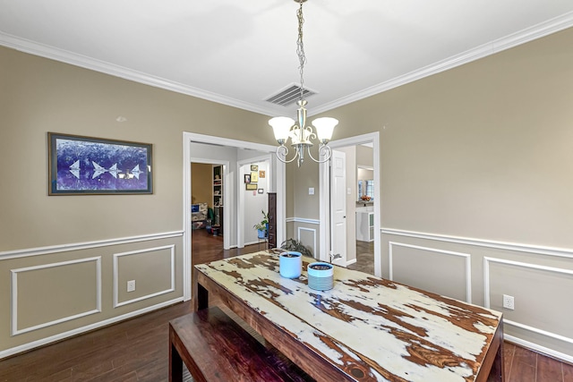 dining room featuring ornamental molding, dark hardwood / wood-style floors, and a chandelier