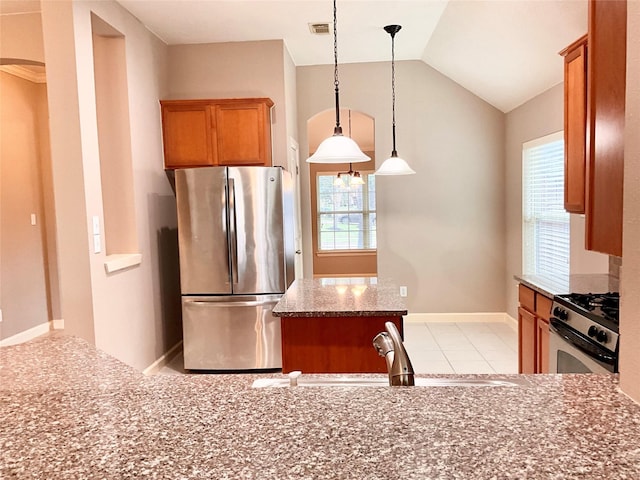 kitchen with lofted ceiling, sink, hanging light fixtures, stainless steel appliances, and a kitchen island