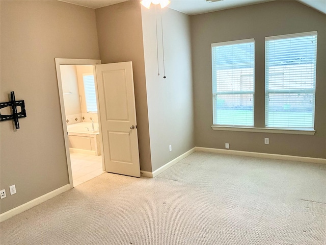 unfurnished bedroom featuring connected bathroom and light colored carpet