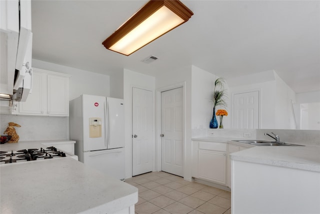 kitchen featuring white cabinetry, light tile patterned flooring, sink, and white fridge with ice dispenser