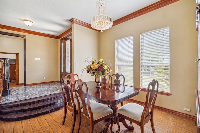 dining space with a notable chandelier, crown molding, and light hardwood / wood-style floors