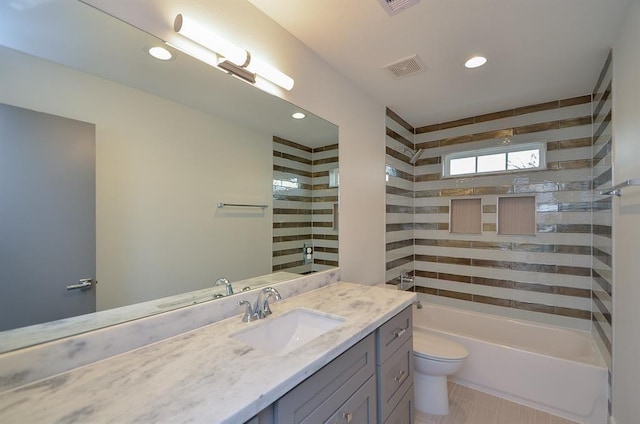 full bathroom featuring vanity, tiled shower / bath, tile patterned flooring, and toilet