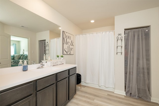 bathroom with wood-type flooring, shower / tub combo, and vanity