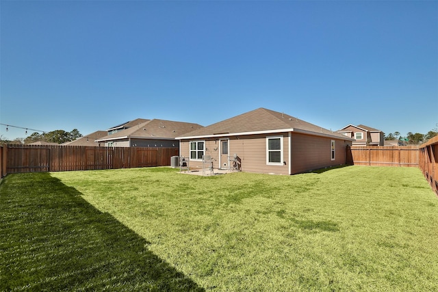 rear view of house with cooling unit, a yard, and a patio area