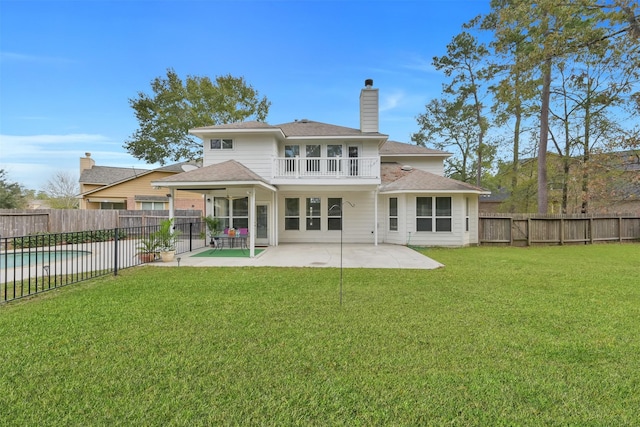 back of house featuring a yard, a patio area, and a balcony