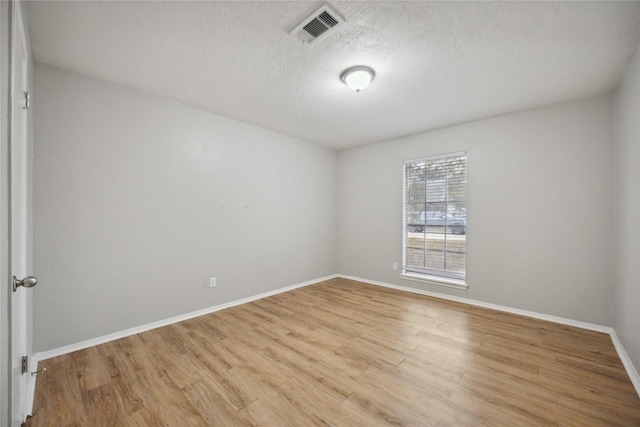 unfurnished room featuring a textured ceiling and light wood-type flooring