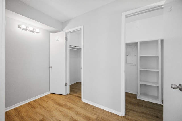 unfurnished bedroom featuring a walk in closet and wood-type flooring