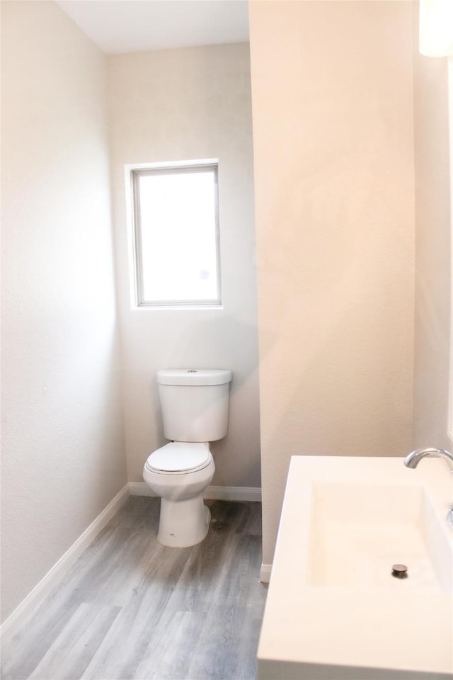 bathroom with wood-type flooring, sink, and toilet