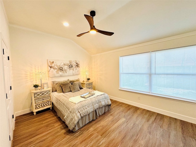 bedroom featuring ornamental molding, vaulted ceiling, baseboards, and wood finished floors