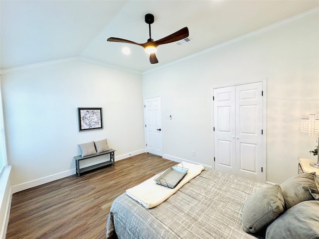 bedroom featuring crown molding, vaulted ceiling, a closet, hardwood / wood-style flooring, and ceiling fan