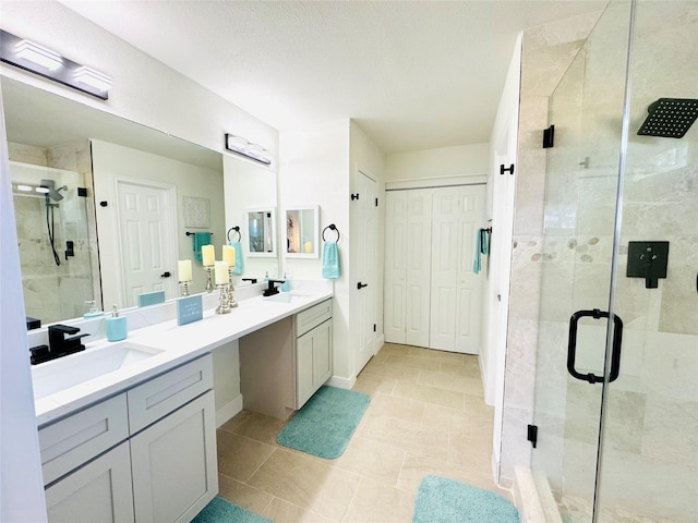 full bathroom featuring double vanity, tile patterned flooring, a sink, and a shower stall