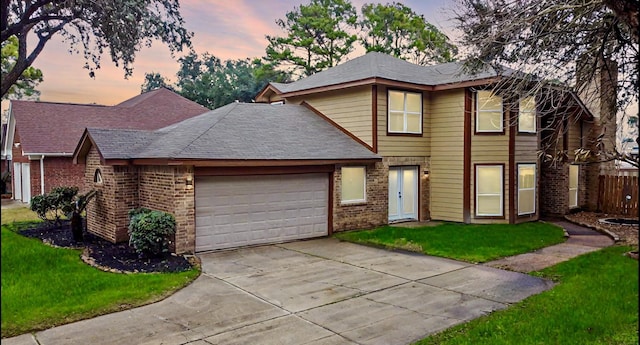 traditional-style house featuring a garage, brick siding, and a front yard