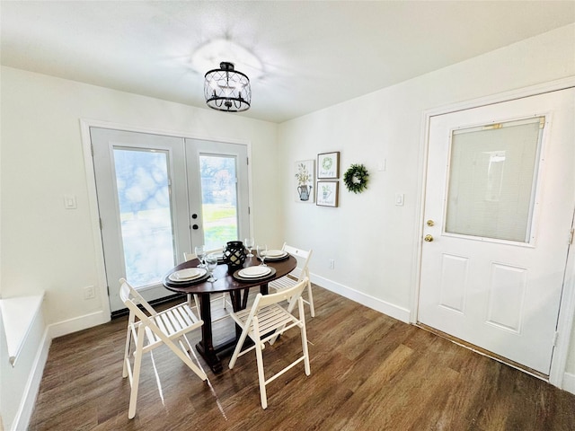 dining space featuring an inviting chandelier, baseboards, wood finished floors, and french doors