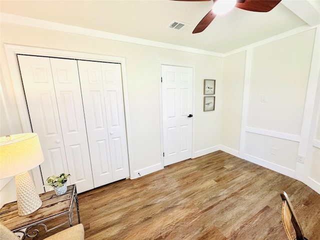 living area featuring crown molding, visible vents, ceiling fan, and wood finished floors