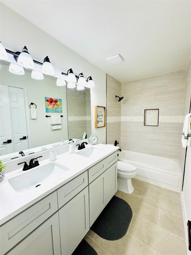 full bathroom featuring vanity, tiled shower / bath combo, tile patterned floors, and toilet