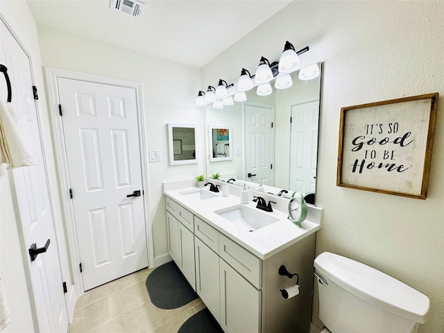 bathroom with double vanity, visible vents, a sink, and tile patterned floors