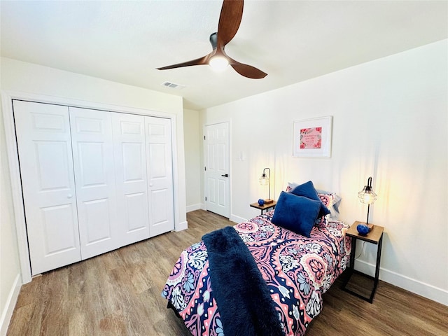 bedroom featuring ceiling fan, wood-type flooring, and a closet