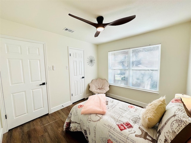 bedroom with ceiling fan, dark wood-style flooring, visible vents, and baseboards