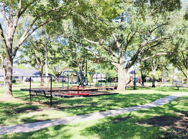 view of property's community featuring playground community and a lawn