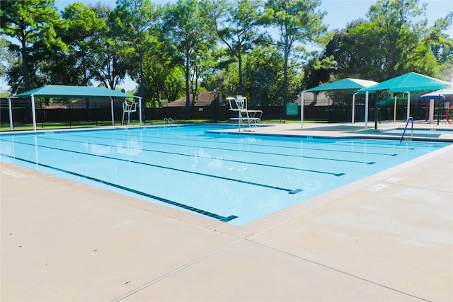 pool with a patio area and fence