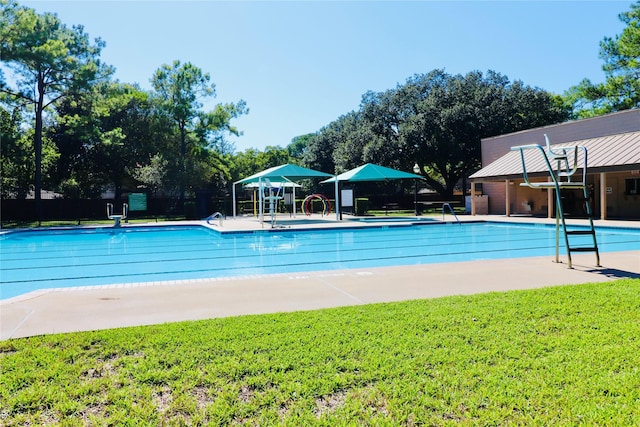 community pool featuring fence, a lawn, and a patio