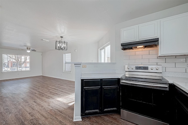 kitchen with dark hardwood / wood-style floors, tasteful backsplash, white cabinets, stainless steel range with electric cooktop, and kitchen peninsula