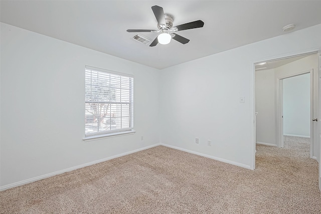 carpeted spare room featuring ceiling fan