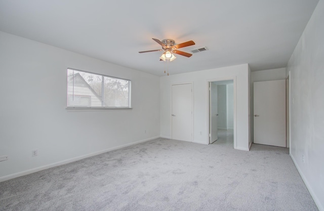 carpeted spare room featuring ceiling fan