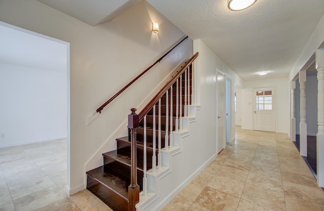 staircase with a textured ceiling